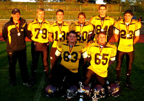 Die Freiburger BaWü-Lions beim Jugendländerturnier in Hamm. Von links stehend: Runningback Coach Jochen Kern, Stefan Hecht, Matthias Amador, Sven Maurer, Oliver Roor, Leon Atmacayan und vorne Karl Schwarz und Dominik Günther.
(Bild: Wolfgang Günther)
Die Freiburger BaWü-Lions beim Jugendländerturnier in Hamm. Von links stehend: Runningback Coach Jochen Kern, Stefan Hecht, Matthias Amador, Sven Maurer, Oliver Roor, Leon Atmacayan und vorne Karl Schwarz und Dominik Günther.
(Bild: Wolfgang Günther)