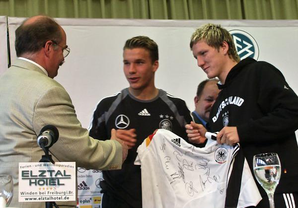 3. Juni 2004: Bastian Schweinsteiger (rechts) überreicht zusammen mit Lukas Podolski ein von allen Spielern unterschriebenes Nationaltrikot an Windens Bürgermeister Clemens Bieniger. Bei einer Pressekonferenz in der Mehrzweckhalle in Winden (Elztal) waren beide 18-Jährige in der Nacht zuvor erstmals zur A-Nationalmannschaft im Trainingslager im Elztal-Hotel gestoßen. Teamchef Rudi Völler hatte sie nach dem Aus bei der U-21-EM tags zuvor in den Kader für die EM 2004 nachnominiert.

Exklusiv-Foto: Reinhard Laniot