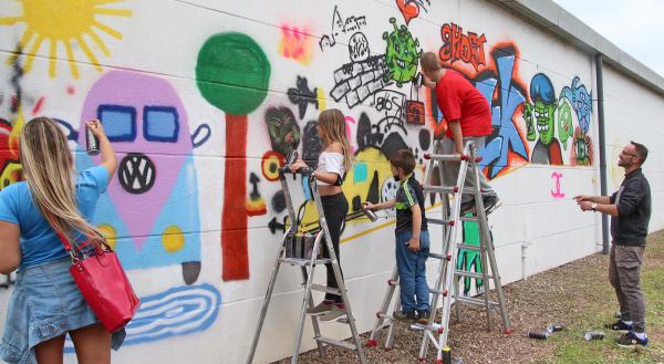 Graffiti-Workshop sorgt für bunte Gebäudefassade an der B3-Umfahrung in Emmendingen - First Class Reisemobil-Center Süd GmbH eröffnet demnächst
Künster Marc Hartmann (rechts) freute sich über engagierte Workshop-Teilnehmer
Foto: "EM-extra" Graffiti-Workshop sorgt für bunte Gebäudefassade an der B3-Umfahrung in Emmendingen - First Class Reisemobil-Center Süd GmbH eröffnet demnächst
Künster Marc Hartmann (rechts) freute sich über engagierte Workshop-Teilnehmer
Foto: "EM-extra"