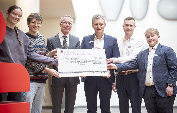 Sparkasse Freiburg-Nördlicher Breisgau setzt Zeichen gegen Rechtsextremismus.
5.000 Euro für Freiburger Landeszentrale für politische Bildung.
Gemeinsam mit Lars Hopp (Vorstandsmitglied der Sparkasse Freiburg-Nördlicher Breisgau) überreichen die Auszubildenden Fabian Münchbach und Maiwand Yousefi einen symbolischen Scheck in Höhe von 5.000 Euro an die beiden Auszubildenden der Landeszentrale für politische Bildung in Freiburg, Kristian Kanstinger und Lätizia Huft, sowie an den Leiter der Landeszentrale, Michael Wehner.
Foto: Sparkasse Freiburg-Nördlicher Breisgau Sparkasse Freiburg-Nördlicher Breisgau setzt Zeichen gegen Rechtsextremismus.
5.000 Euro für Freiburger Landeszentrale für politische Bildung.
Gemeinsam mit Lars Hopp (Vorstandsmitglied der Sparkasse Freiburg-Nördlicher Breisgau) überreichen die Auszubildenden Fabian Münchbach und Maiwand Yousefi einen symbolischen Scheck in Höhe von 5.000 Euro an die beiden Auszubildenden der Landeszentrale für politische Bildung in Freiburg, Kristian Kanstinger und Lätizia Huft, sowie an den Leiter der Landeszentrale, Michael Wehner.
Foto: Sparkasse Freiburg-Nördlicher Breisgau