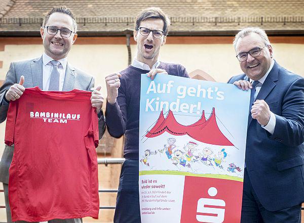 19. Juli 2024: Sparkasse Freiburg-Nördlicher Breisgau lädt zum 39. Bambinilauf ein.
Von links: Marc Winsheimer (Leiter Gesellschaftliches Engagement der Sparkasse Freiburg-Nördlicher Breisgau und Organisator des Bambinilaufs), Freiburgs Oberbürgermeister Martin Horn und Daniel Zeiler (Vorstandsvorsitzender der Sparkasse) rühren gemeinsam die Werbetrommel für den 39. Bambinilauf.
Foto: Sparkasse Freiburg-Nördlicher Breisgau - Patrick Kunkel 19. Juli 2024: Sparkasse Freiburg-Nördlicher Breisgau lädt zum 39. Bambinilauf ein.
Von links: Marc Winsheimer (Leiter Gesellschaftliches Engagement der Sparkasse Freiburg-Nördlicher Breisgau und Organisator des Bambinilaufs), Freiburgs Oberbürgermeister Martin Horn und Daniel Zeiler (Vorstandsvorsitzender der Sparkasse) rühren gemeinsam die Werbetrommel für den 39. Bambinilauf.
Foto: Sparkasse Freiburg-Nördlicher Breisgau - Patrick Kunkel