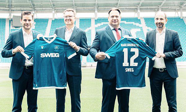 Südwestdeutsche Landesverkehrs-GmbH ist neuer Hauptpartner des Karlsruher SC.
Von links: Michael Becker (KSC-Geschäftsführer), Tobias Harms (Vorsitzender der SWEG-Geschäftsführung), Thilo Grabo (SWEG-Geschäftsführer) und Christan Jäger (Leiter Bereich B2B & Events beim KSC) bei der offiziellen Präsentation des neuen KSC-Trikots.
Foto: SWEG Südwestdeutsche Landesverkehrs-GmbH - Karlsruher SC Südwestdeutsche Landesverkehrs-GmbH ist neuer Hauptpartner des Karlsruher SC.
Von links: Michael Becker (KSC-Geschäftsführer), Tobias Harms (Vorsitzender der SWEG-Geschäftsführung), Thilo Grabo (SWEG-Geschäftsführer) und Christan Jäger (Leiter Bereich B2B & Events beim KSC) bei der offiziellen Präsentation des neuen KSC-Trikots.
Foto: SWEG Südwestdeutsche Landesverkehrs-GmbH - Karlsruher SC