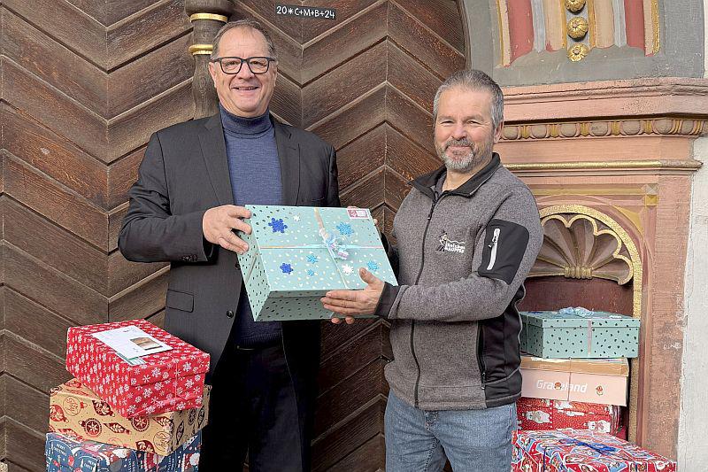 Oberbürgermeister Roth überreichte Geschenke für "Weihnachten im Schuhkarton" in Villingen-Schwenningen.
Oberbürgermeister Jürgen Roth (links) übergibt die 51 Geschenke an Martin Jäckle, der die Aktion in Villingen-Schwenningen koordiniert.
Foto: Stadt Villingen-Schwenningen - Patrick Ganter Oberbürgermeister Roth überreichte Geschenke für "Weihnachten im Schuhkarton" in Villingen-Schwenningen.
Oberbürgermeister Jürgen Roth (links) übergibt die 51 Geschenke an Martin Jäckle, der die Aktion in Villingen-Schwenningen koordiniert.
Foto: Stadt Villingen-Schwenningen - Patrick Ganter